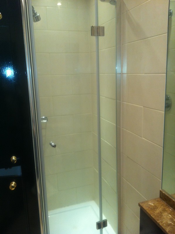 Frameless glass shower enclosure with chrome fittings in Banstead