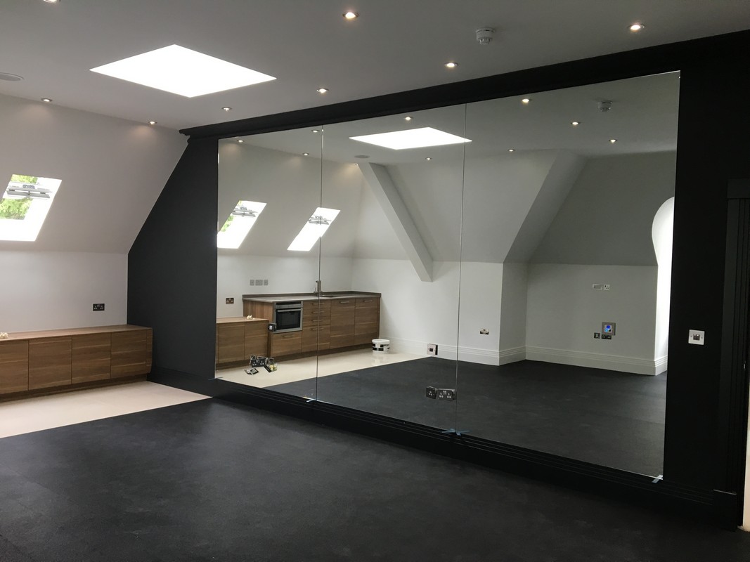 Frameless glass wall dividing loft conversion in Banstead